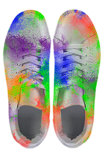 Sneakers covered in paint splashes. Colorful sneakers on a white background. Creative shoes.