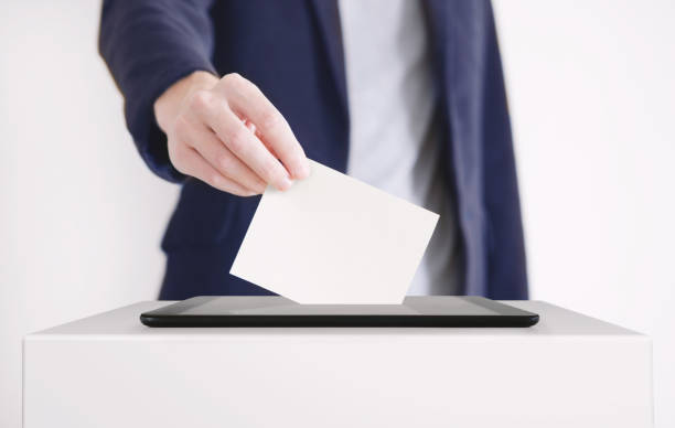 デジタルタブレットに投票用紙を入れるビジネスマン。投票オンラインコンセプト。 - voting election voting ballot choice ストックフォトと画像