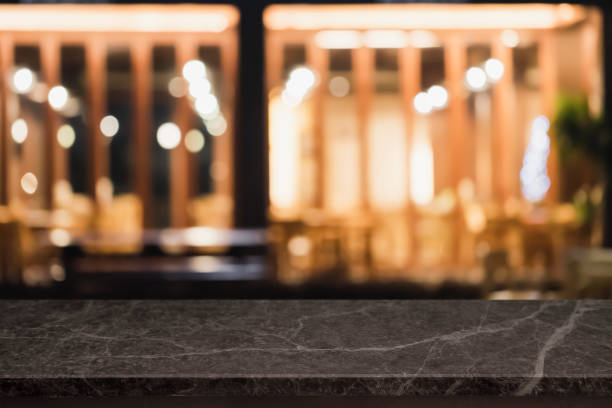 istock Empty black marble stone table top and blurred coffee shop and restaurant interior background - can used for display or montage your products. 1255692311