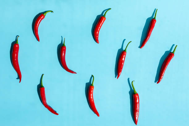 istock Flat lay red chili peppers pattern on yellow or blue background. Top view 1255692755