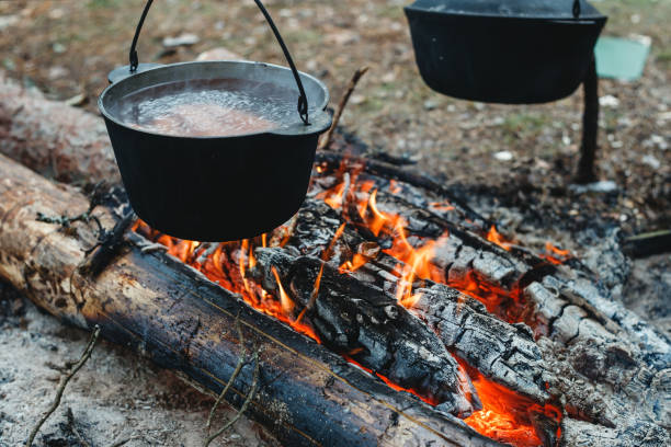 istock Cooking over a campfire in a pot, in a camping 1255696698