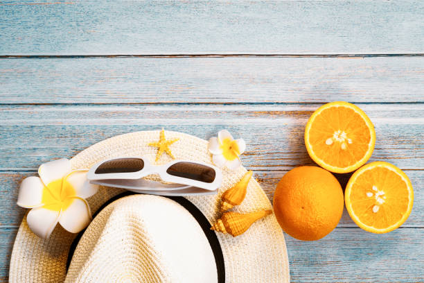 красивый летний отдых, пляжные аксессуары, солнцезащитные очки, шляпа, апельсины и ракушки на деревянном фоне - shell starfish orange sea стоковые фото и изображения