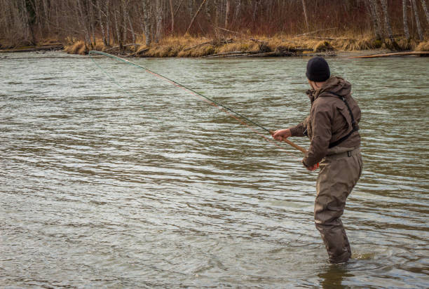 istock A fly fisherman hooked into a big fish in a river with the rod bent 1255700340