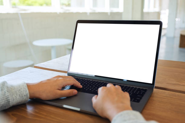 istock a woman using and typing on laptop computer keyboard with blank white desktop screen on wooden table 1255700541