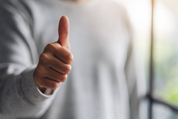 istock a woman making and showing thumbs up hand sign 1255700585