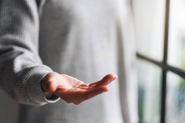 istock a woman showing open hand palm with copy space for text or product 1255700608