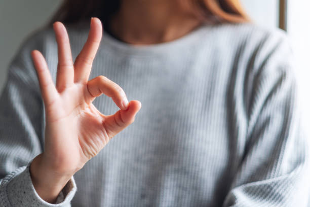 istock a young woman making and showing ok hand sign 1255701122