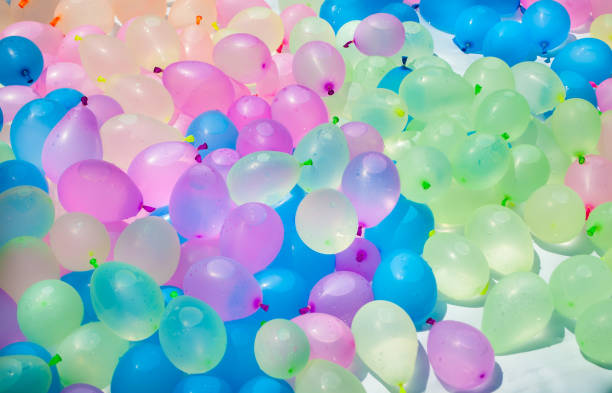 Multi-colored balloons filled with water prepared for the game Multi-colored balloons filled with water prepared for the water game of children and adolescents water balloon stock pictures, royalty-free photos & images