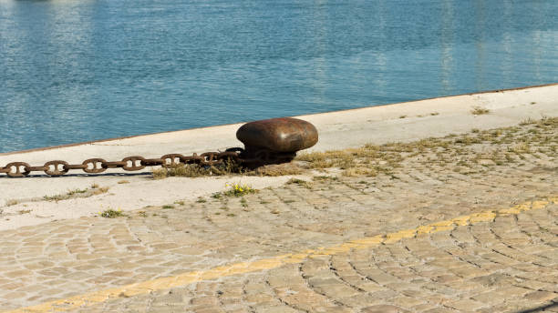 istock Rusty mooring bollard with an iron chain on the harbor pier (Pesaro, Italy, Europe) 1255707642