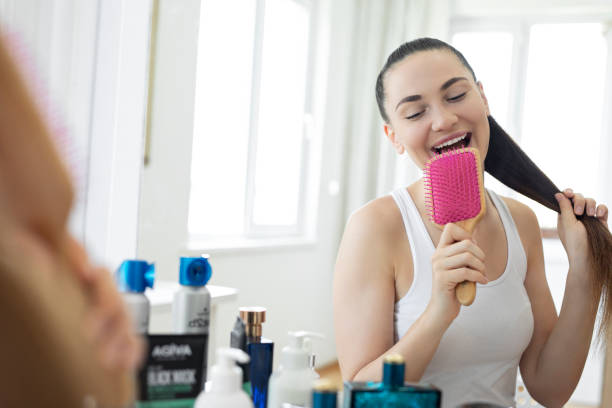 istock Young woman singing while brushing her hair at home 1255708347