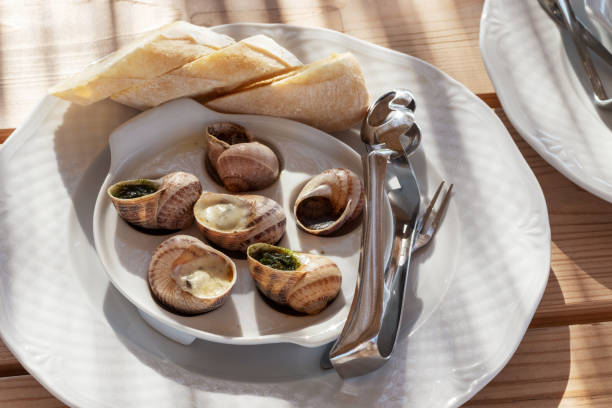 istock Plate with cooked snails and cutlery for eating snails. 1255708487