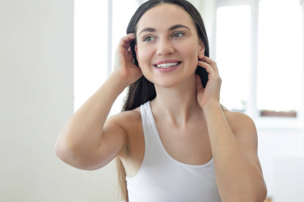 istock Young woman admiring her face in the mirror 1255709271