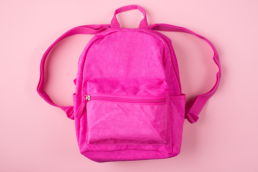 Top above overhead view photo of pink backpack isolated on pastel pink background