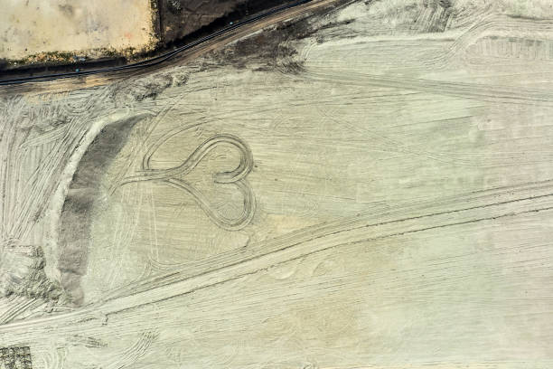 istock Top view on a heart drawn in quarry from coal. Heart from sand. 1255711106