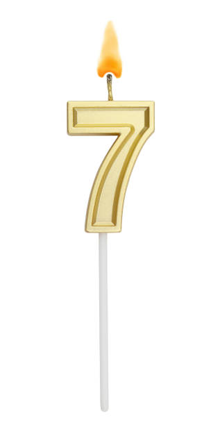 istock Birthday golden candle on white background, number 7 1255713659