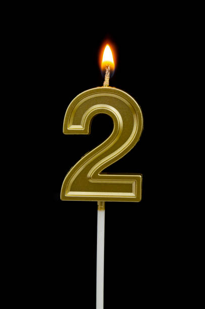istock Birthday golden candle on black background, number 2 1255713702