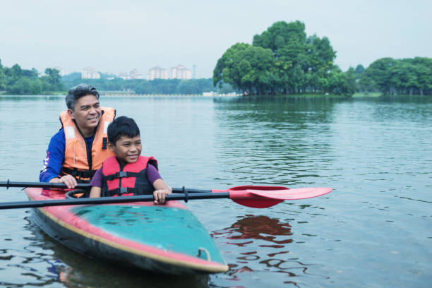 asian man appreciating time with his son in the outdoors - family kayaking kayak canoeing imagens e fotografias de stock