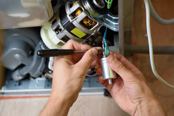 istock handyman repairs dishwasher with screwdriver 1255713800