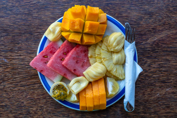 istock Tropical fruits on a breakfast plate, close up, top view 1255713908