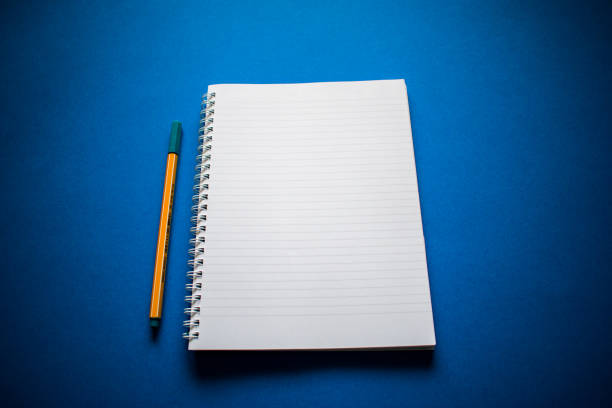 istock White notebook with yellow pencil on blue background 1255716299