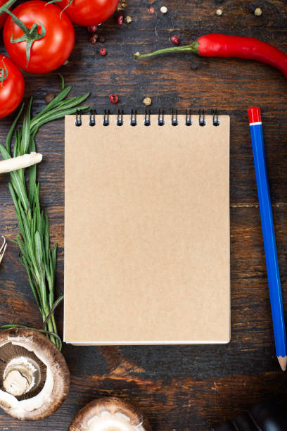 istock vegetables and a paper notebook on a spiral, on a brown wooden background. 1255717308
