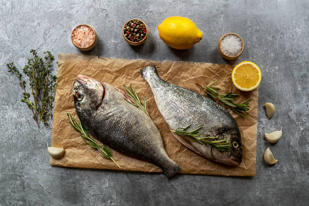 istock Sea breams and ingredients for seasoning and cooking dorada fish 1255717457