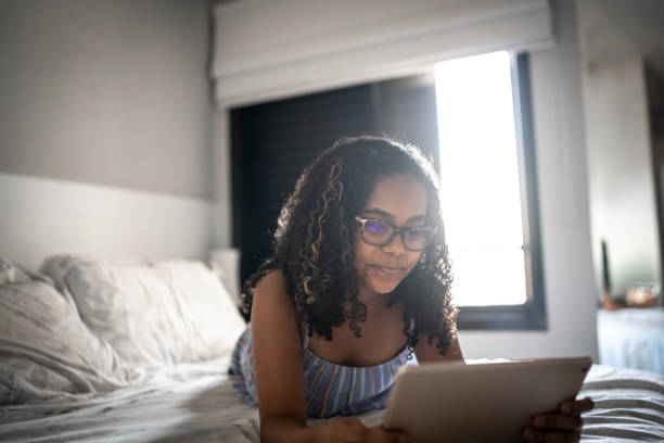 istock Teenager reading on digital tablet at home 1255718444