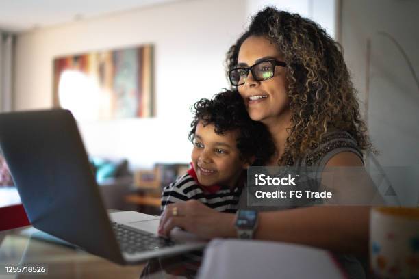 Mature Woman Working At Home Carrying Young Son Stock Photo - Download Image Now - Family, Child, Mother