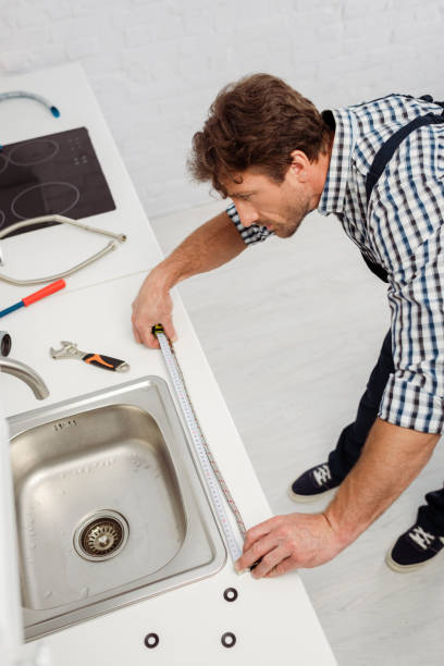 istock High angle view of plumber using industrial measuring tape near sink and tools on kitchen worktop 1255719252