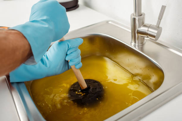 Cropped view of plumber in rubber gloves holding plunger while cleaning blockage of kitchen sink Cropped view of plumber in rubber gloves holding plunger while cleaning blockage of kitchen sink kitchen sink photos stock pictures, royalty-free photos & images