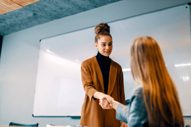 istock young professional businesswoman talking and shaking hands in office 1255720659