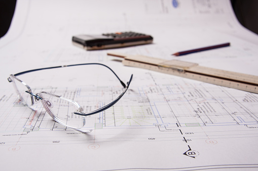 construction stillife with glasses calculator pencil and ruler are on the planning paper