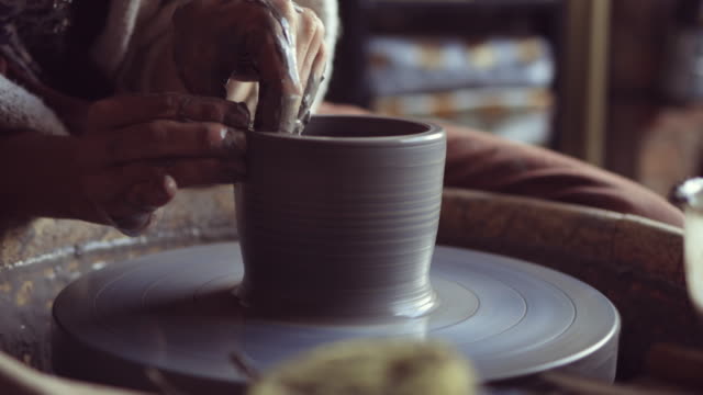 Woman making ceramic work with potter's wheel