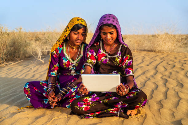 istock Happy Gypsy Indian girls using digital tablet, India 1255724375