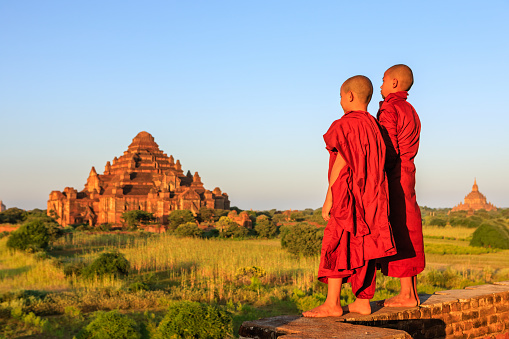 Young Buddhist monks admiring view of ancient temples in Bagan, Myanmar (Burma)