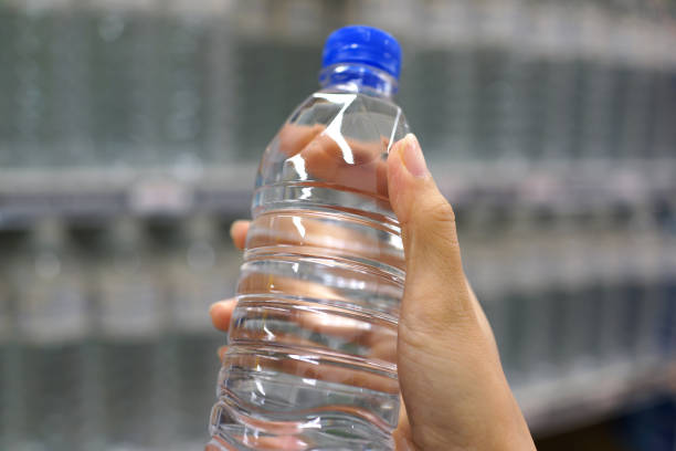 istock Female Holding Water Bottle In Grocery Store 1255725151