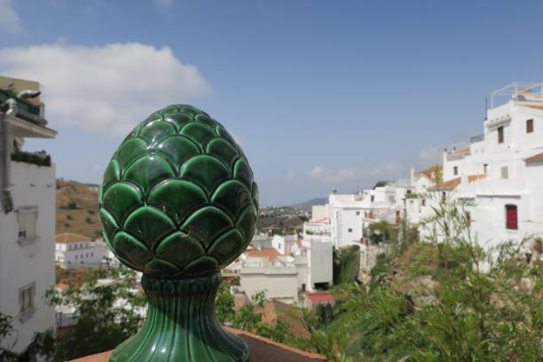 a green ceramic decoration on a wall with a view on Competa