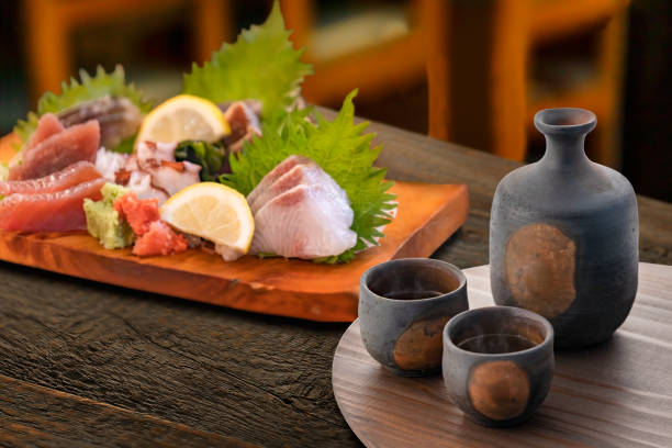 sake ve lezzetli sashimi - sashimi stok fotoğraflar ve resimler
