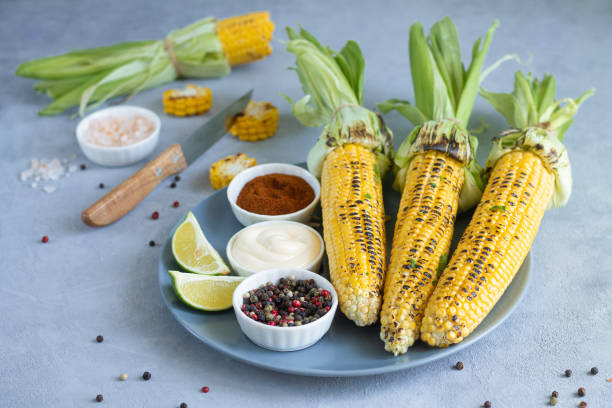 istock Delicious grilled sweet corn cobs for dinner on gray stone background 1255730573