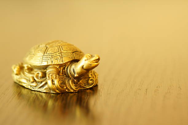 Metal turtle on a gold background.