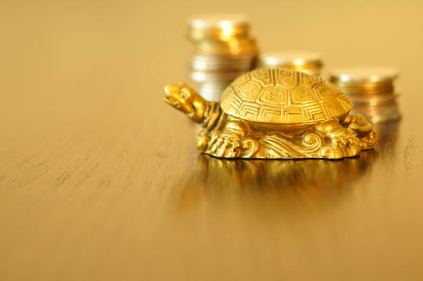 istock Metal turtle on a gold background. 1255733990
