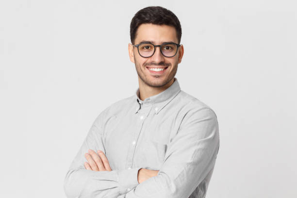 Young handsome business man wearing gray shirt and eyeglasses, holding arms crossed, smiling and feeling confident, isolated Young handsome business man wearing gray shirt and eyeglasses, holding arms crossed, smiling and feeling confident, isolated one young man only photos stock pictures, royalty-free photos & images