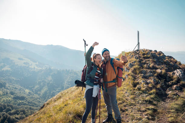 istock Young couple taking a selfie while out hiking 1255737601