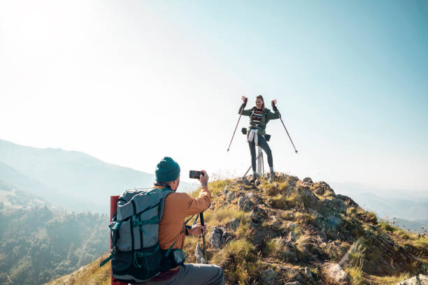 istock Young couple taking pictures while out hiking 1255739282
