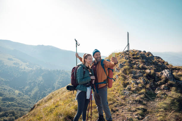 istock Young couple taking a selfie while out hiking 1255739665