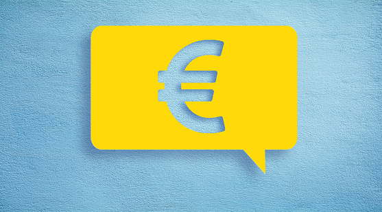 Finance and business concept, Euro icon or sign on vibrant yellow speech bubble on blue color real concrete wall with copy space.