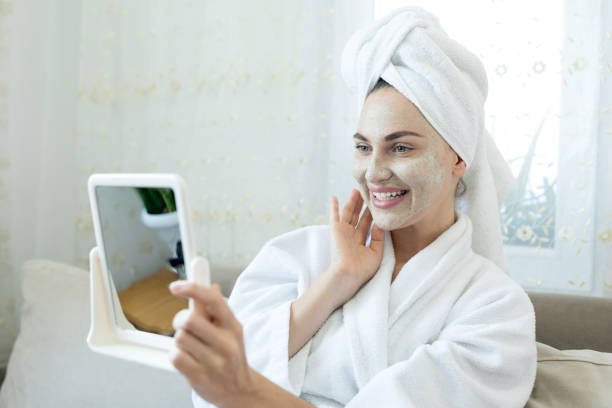 istock Young woman applying facial mask 1255741748