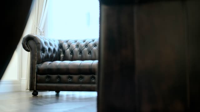 dolly shot of old style leather sofa in contemporary formal living room home interior design concept