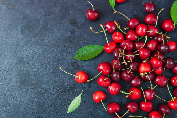 istock Cherry with leaf on plate and water dropsand on grey stone table 1255743287