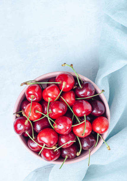 istock Cherry with leaf on plate and water drops on grey stone table 1255744311